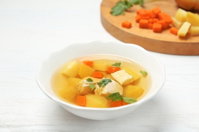 Photo of Dish with fresh homemade chicken soup on wooden table