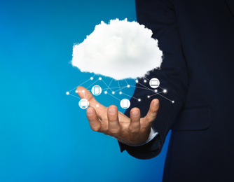 Modern storage technology concept. Man demonstrating cloud with icons on light blue background, closeup