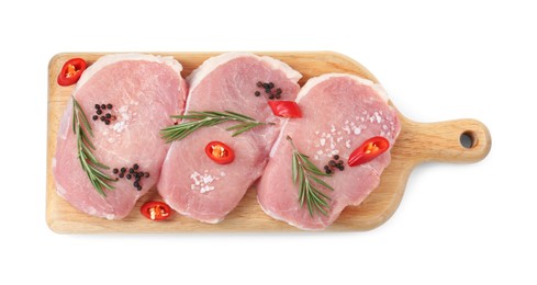 Wooden board with pieces of raw pork meat and spices isolated on white, top view