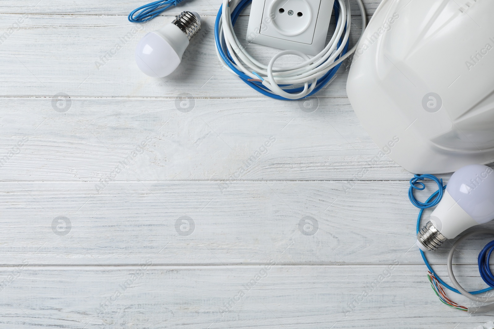Photo of Set of electrician's accessories on white wooden background, space for text