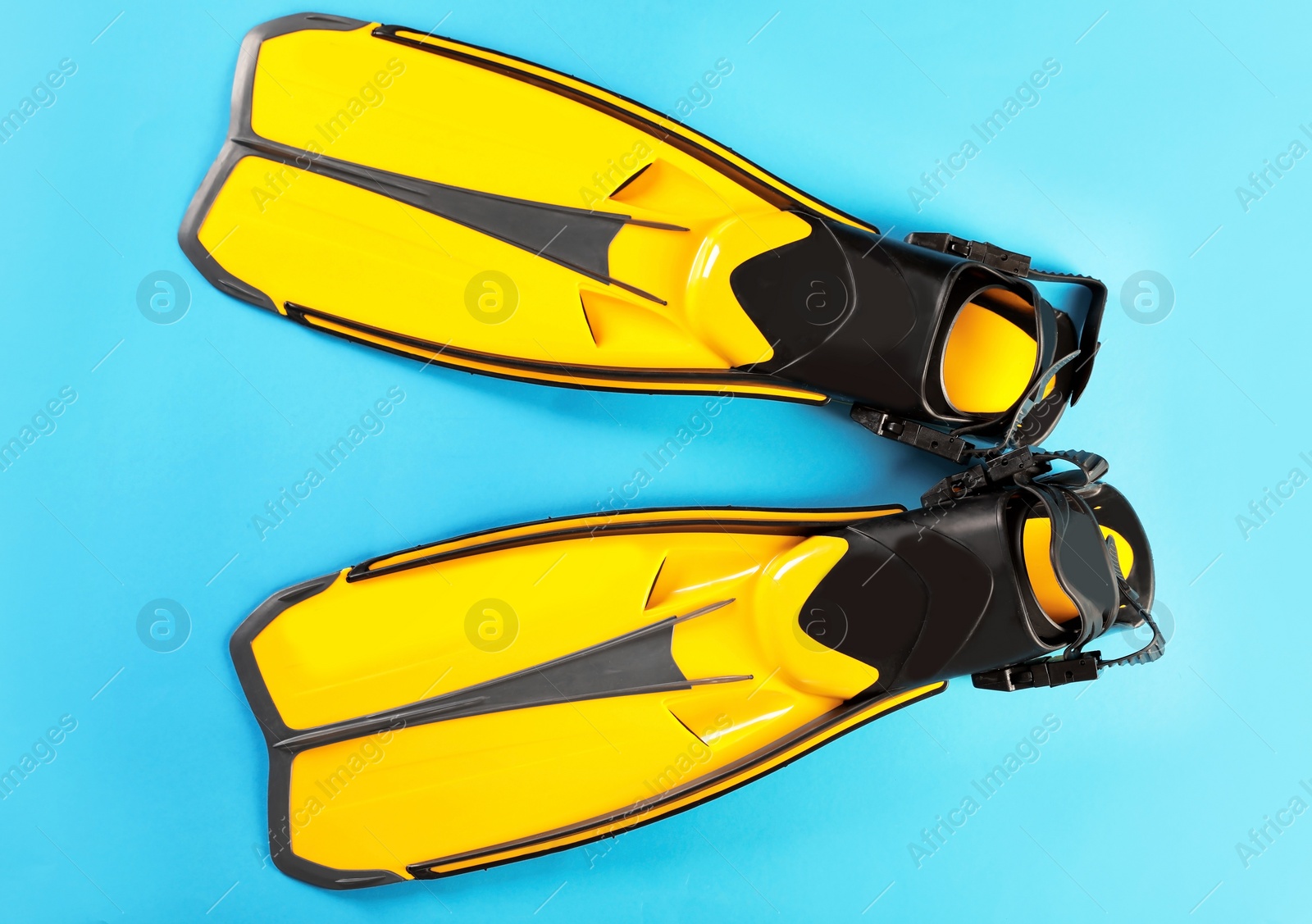 Photo of Pair of yellow flippers on color background, top view