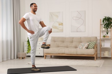 Man doing morning exercise on fitness mat at home