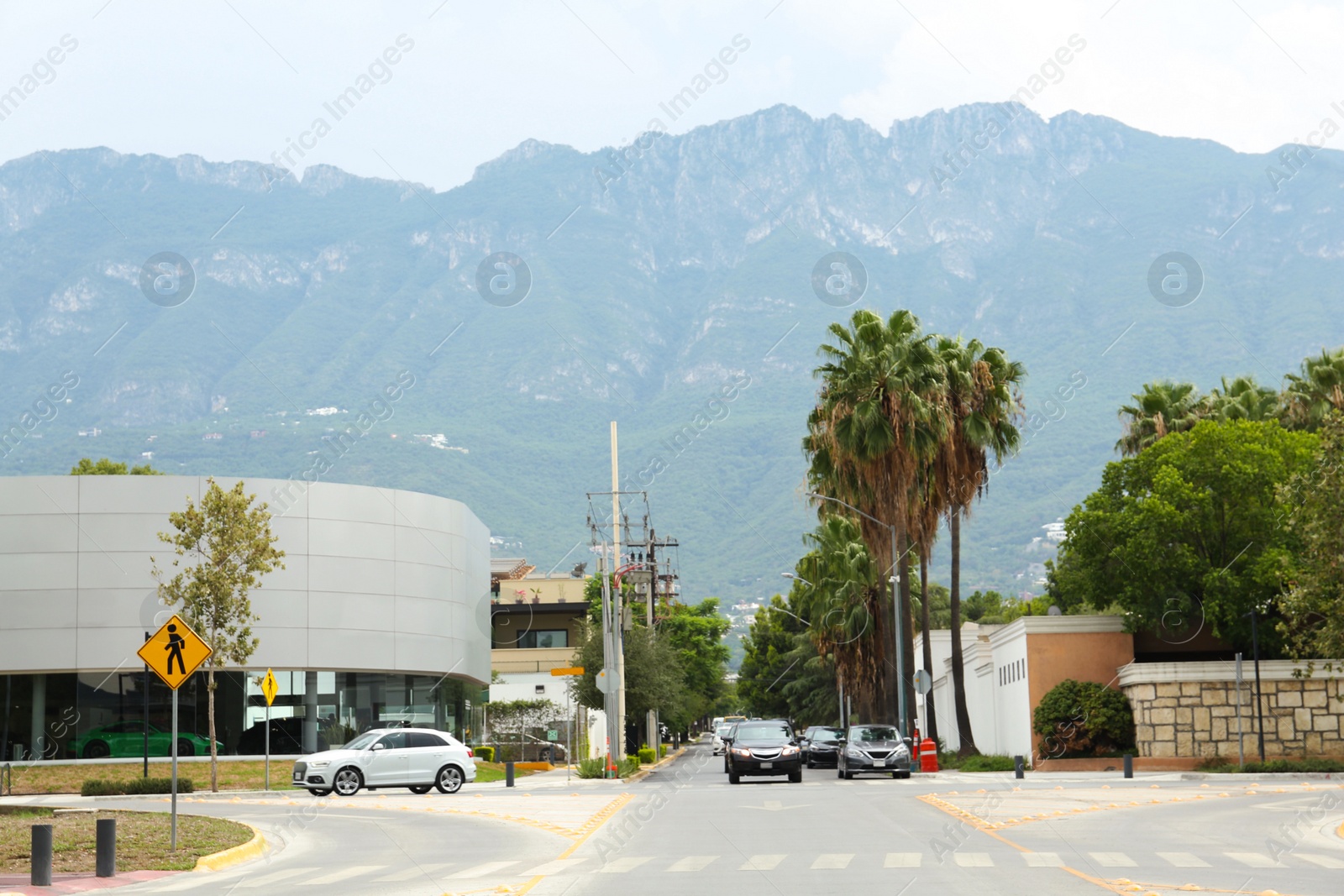 Photo of Asphalt road with cars and trees near mountains