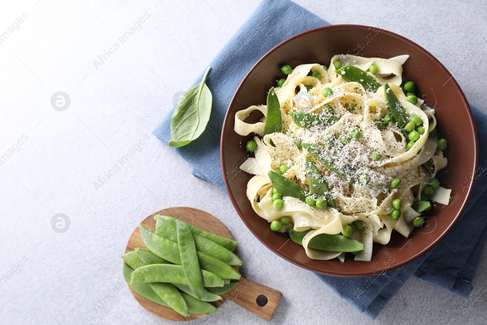 Photo of Delicious pasta with green peas and ingredients on grey table, flat lay. Space for text