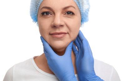 Photo of Doctor examining mature woman on white background. Double chin surgery