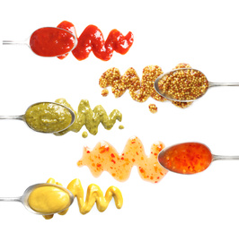 Image of Set of spoons with different delicious sauces on white background, top view