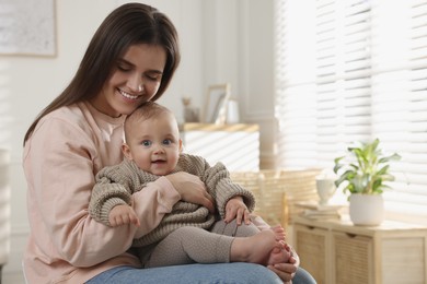 Photo of Happy young mother with her baby at home. Space for text