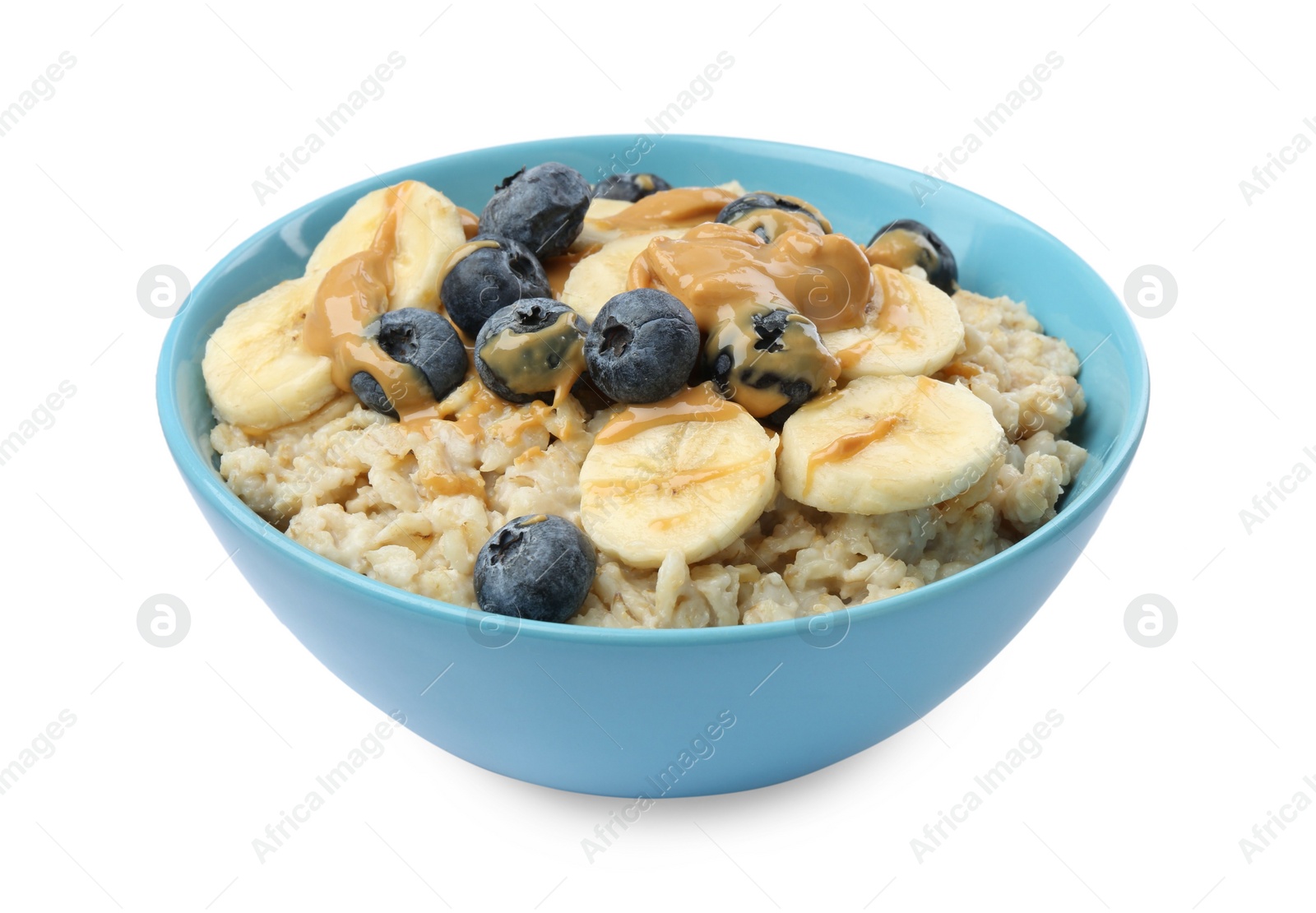 Photo of Tasty oatmeal with banana, blueberries and peanut butter in bowl isolated on white