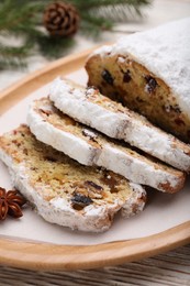 Photo of Traditional Christmas Stollen with icing sugar on white wooden table, closeup