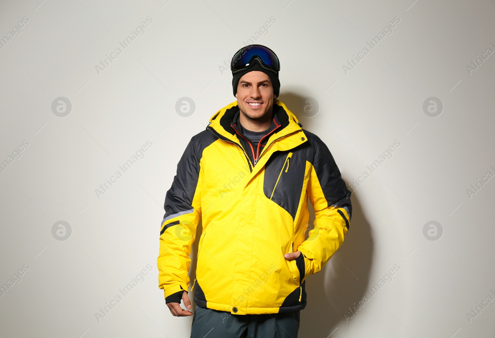 Photo of Man wearing stylish winter sport clothes on light grey background