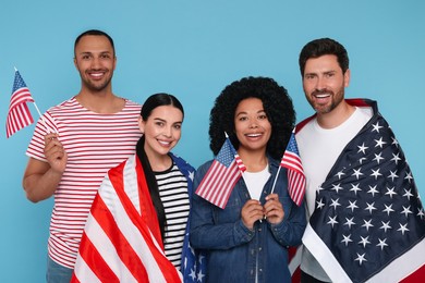 4th of July - Independence Day of USA. Happy friends with American flags on light blue background