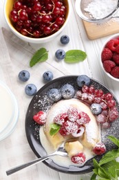 Delicious vanilla fondant served with fresh berries on white wooden table, flat lay