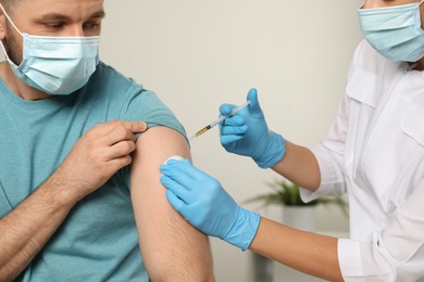 Photo of Doctor giving injection to patient in hospital, closeup. Vaccination day