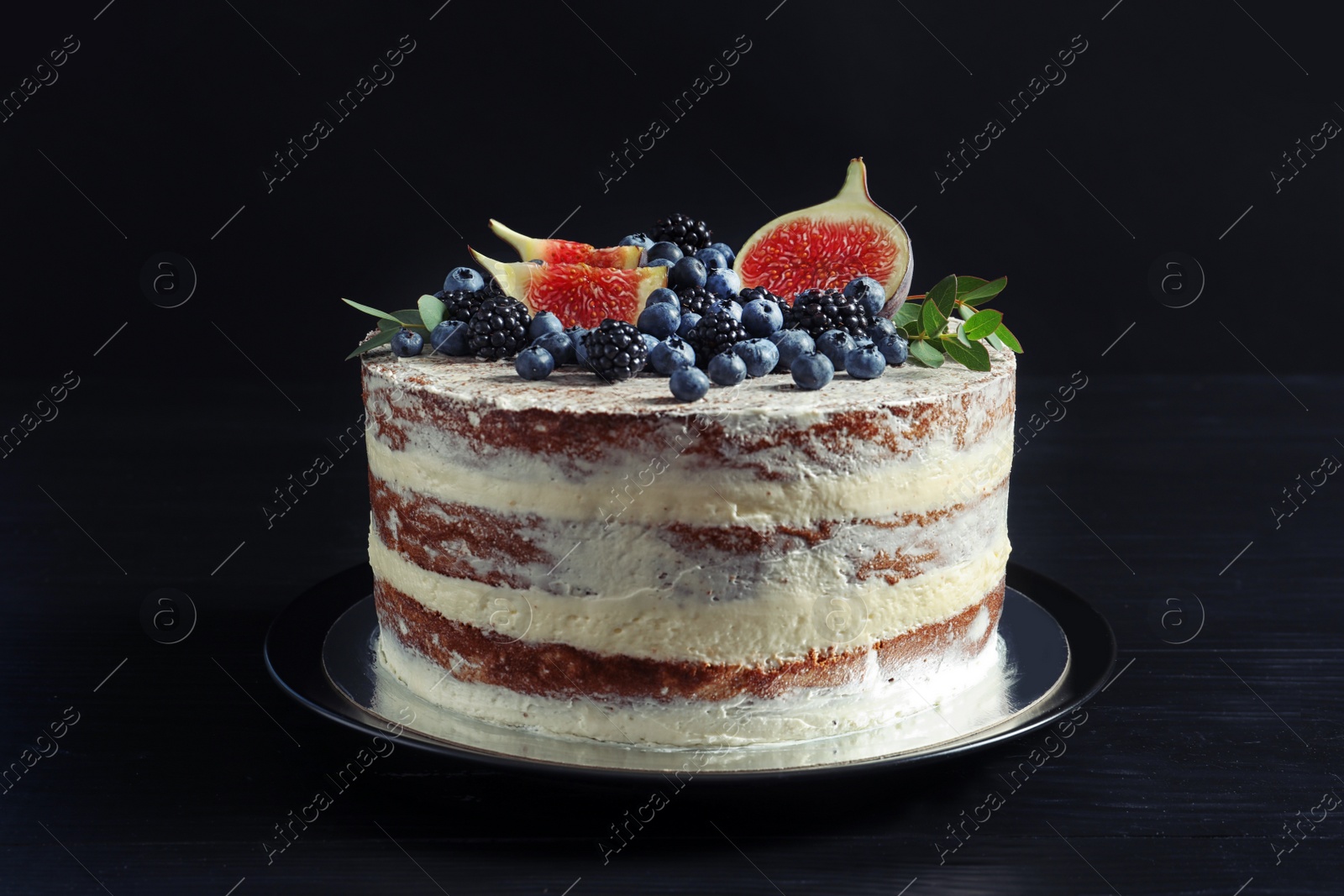 Photo of Delicious homemade cake with fresh berries on dark wooden table