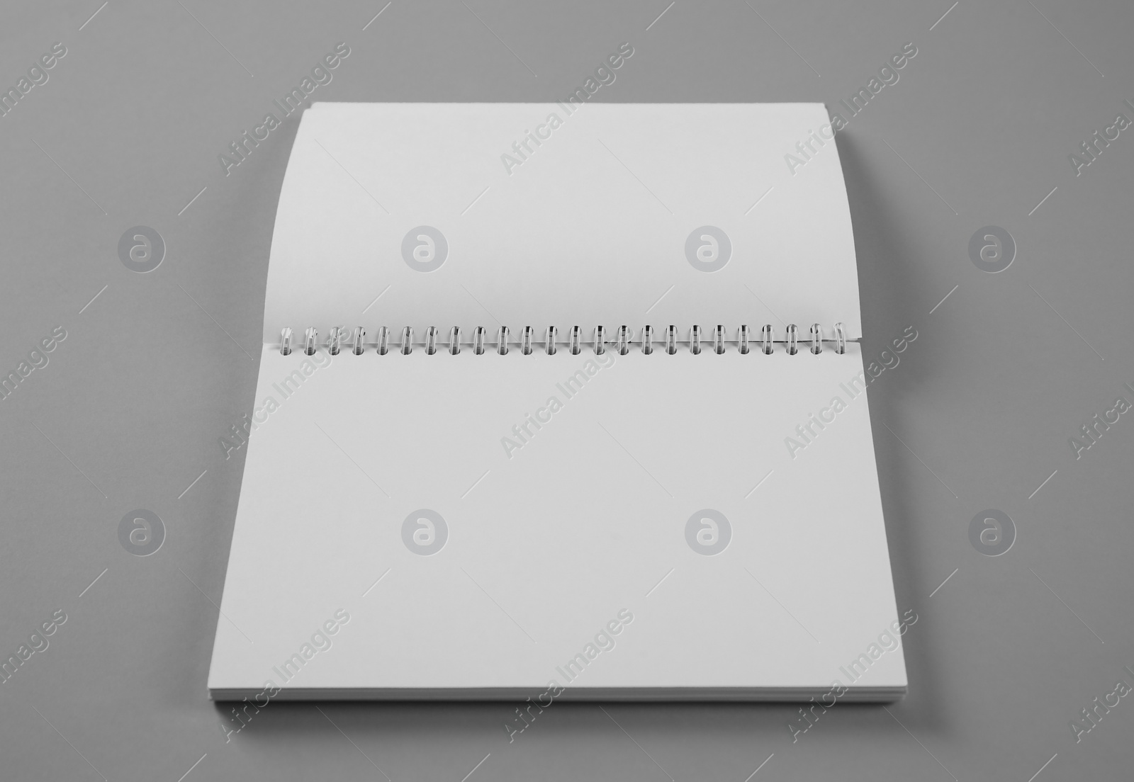 Photo of Open blank notebook on grey background. Mockup for design