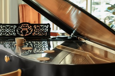 Photo of Cup and coasters on black grand piano in cafe