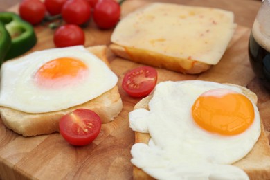 Photo of Tasty toasts with fried eggs and tomatoes on wooden table, closeup