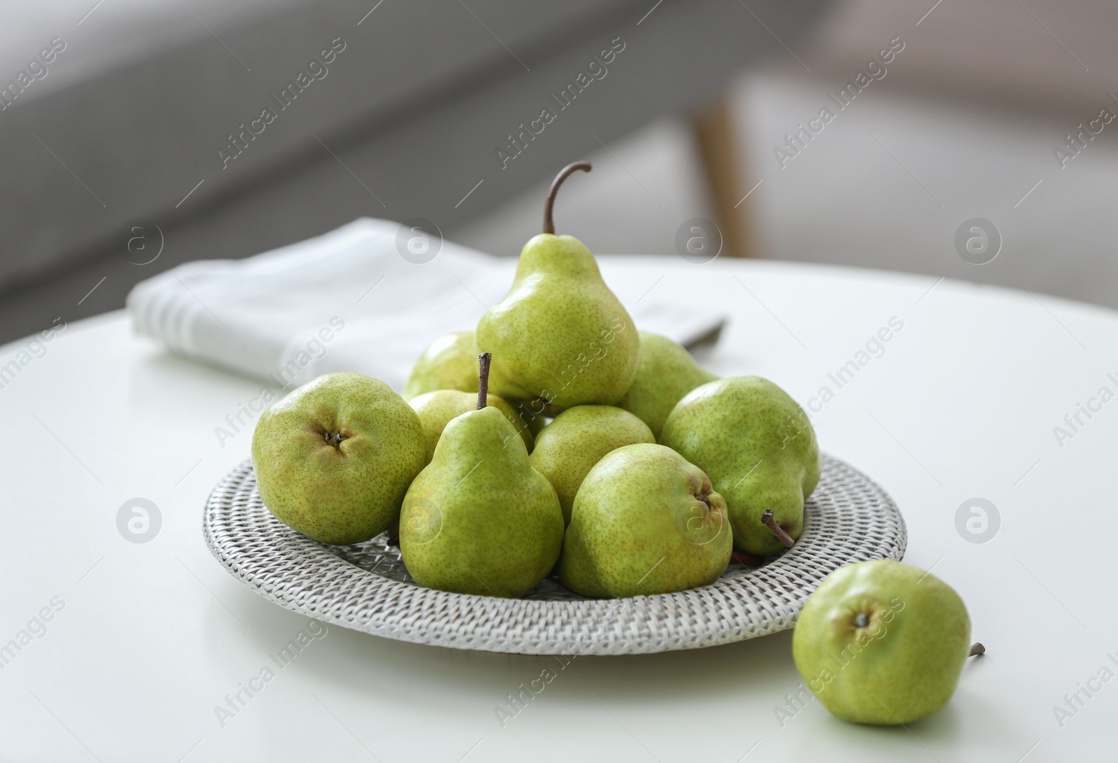 Photo of Fresh ripe pears on white table in room