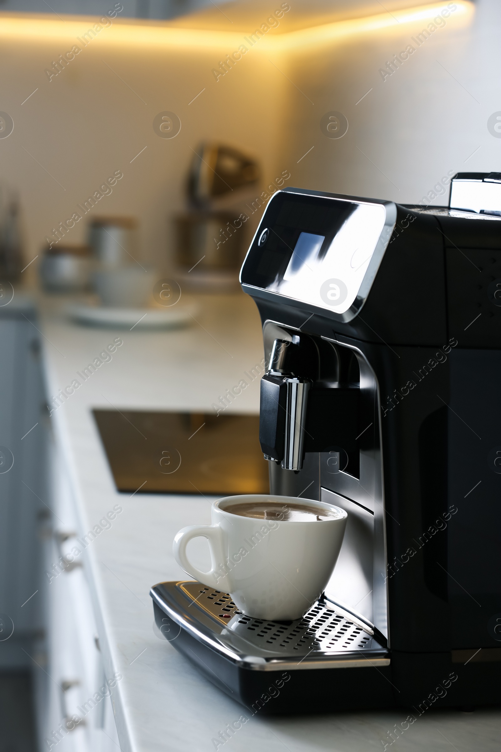 Photo of Modern electric espresso machine with cup of coffee on white marble countertop in kitchen