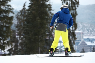 Photo of Snowboarder on slope at resort, space for text. Winter vacation