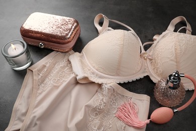 Photo of Elegant beige plus size women's underwear, perfume, clutch and candle on grey background
