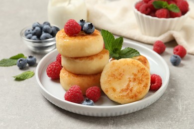 Delicious cottage cheese pancakes with berries on light table
