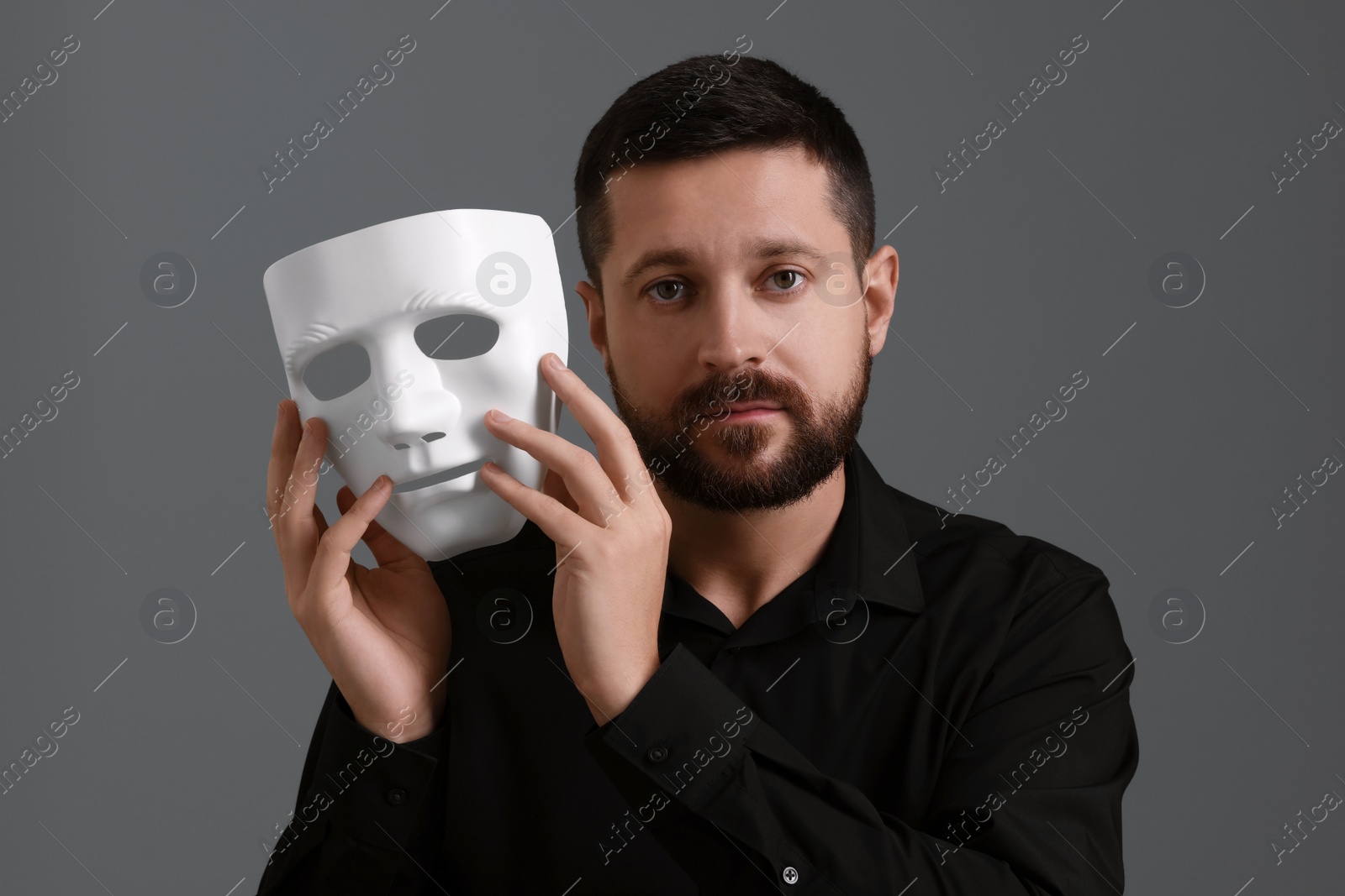 Photo of Multiple personality concept. Man with mask on grey background