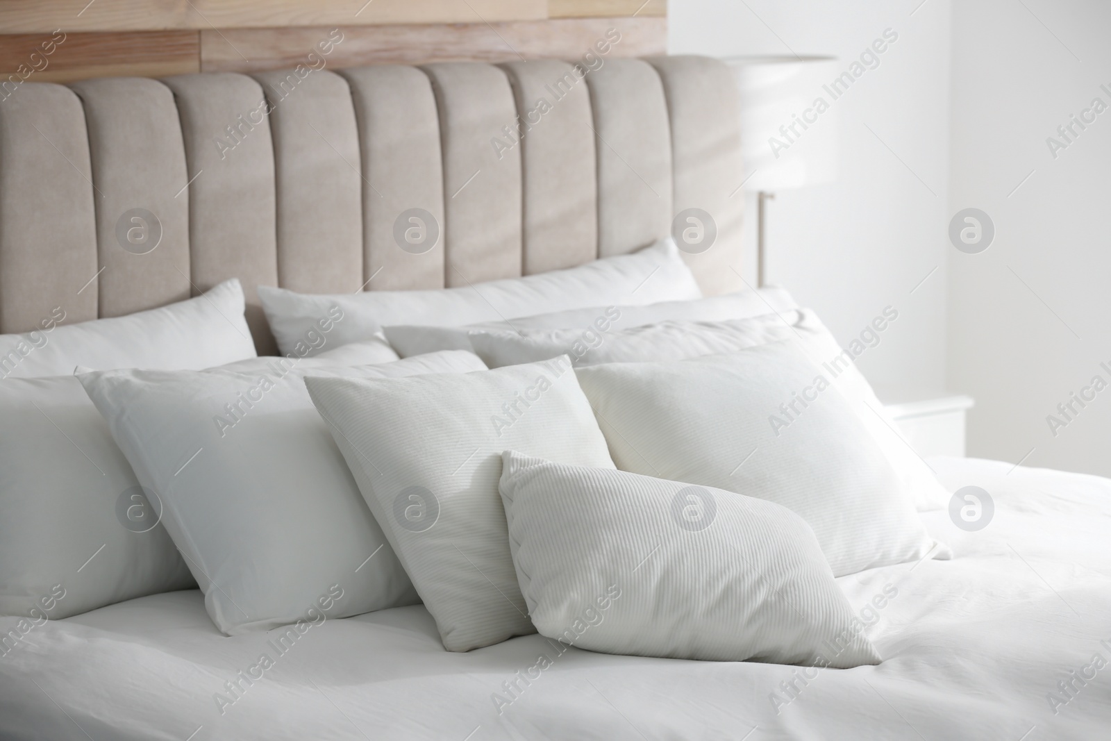 Photo of Comfortable bed with soft white pillows indoors