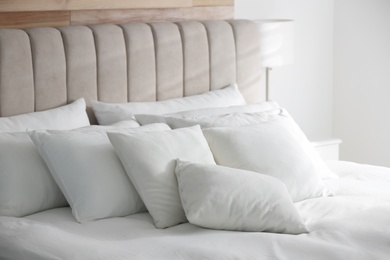 Comfortable bed with soft white pillows indoors