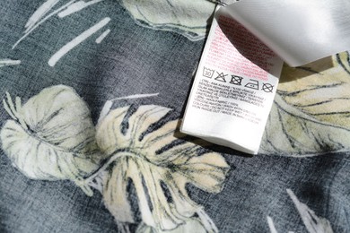 Photo of Clothing label on garment with floral pattern, top view