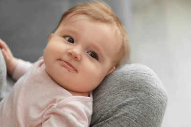 Photo of Young woman with her cute baby at home, closeup