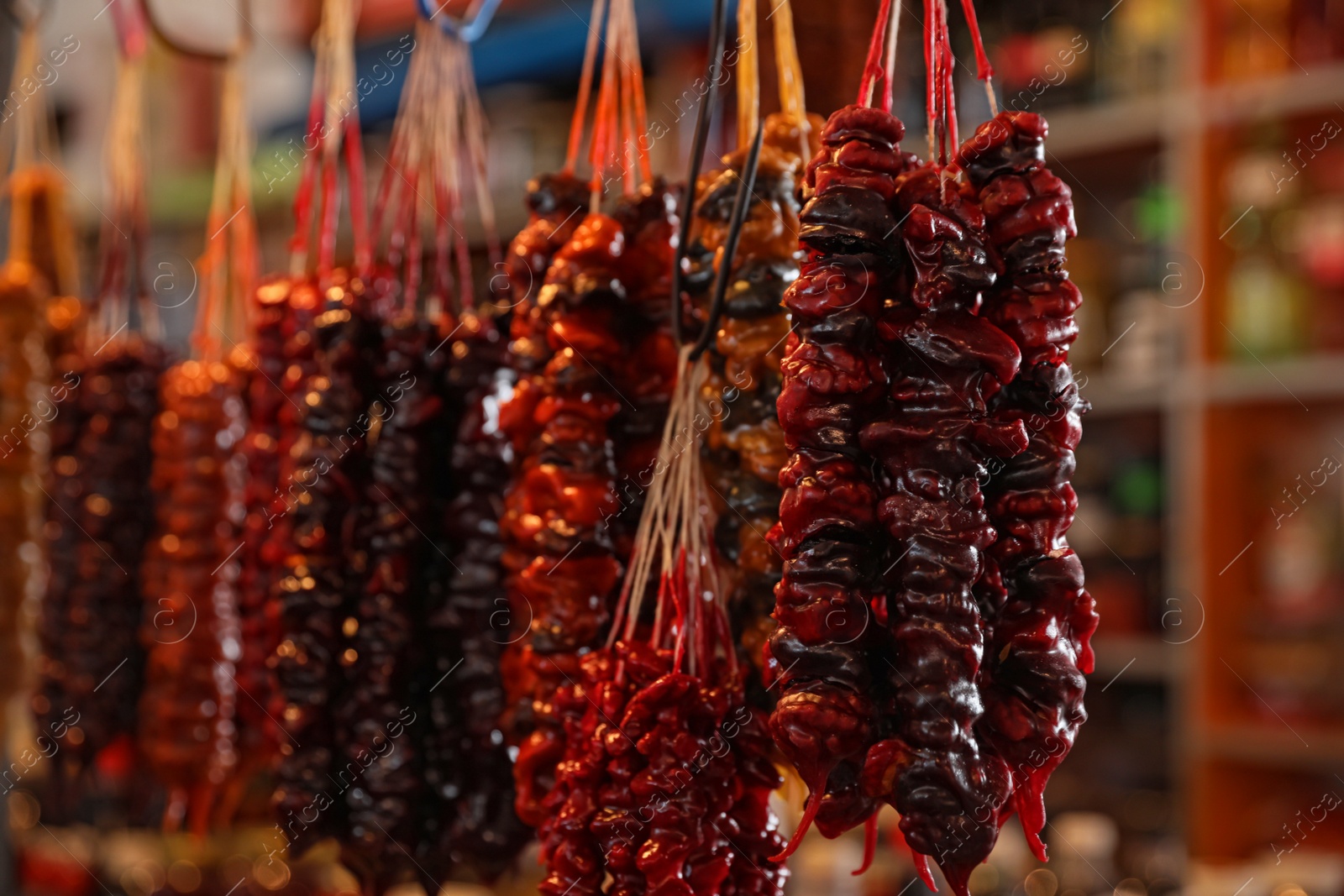 Photo of Bunches of different delicious churchkhelas at market, closeup. Space for text