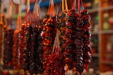 Bunches of different delicious churchkhelas at market, closeup. Space for text