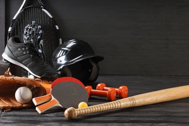 Photo of Many different sports equipment on dark grey wooden table, space for text