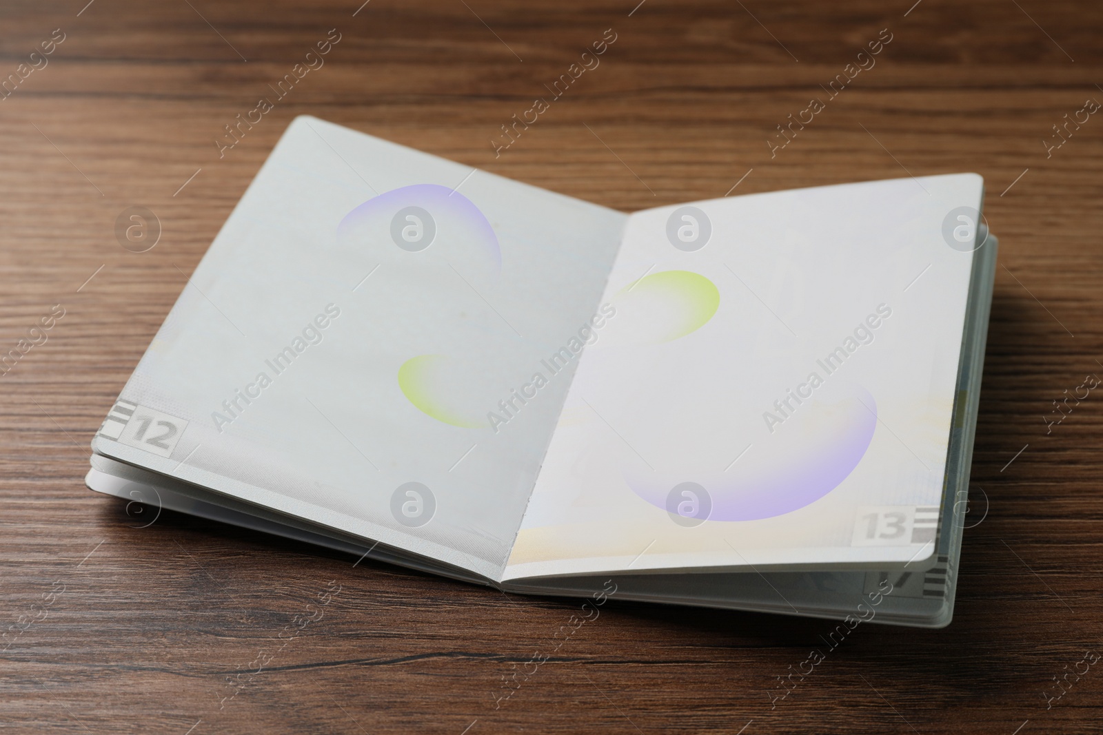 Photo of Blank open passport on wooden table, closeup