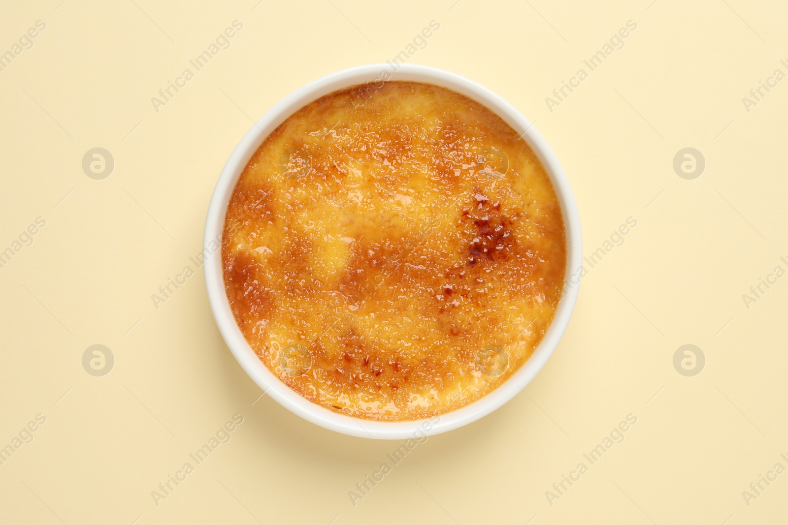 Photo of Delicious creme brulee on beige background, top view