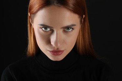 Photo of Evil eye. Young woman with scary eyes on black background