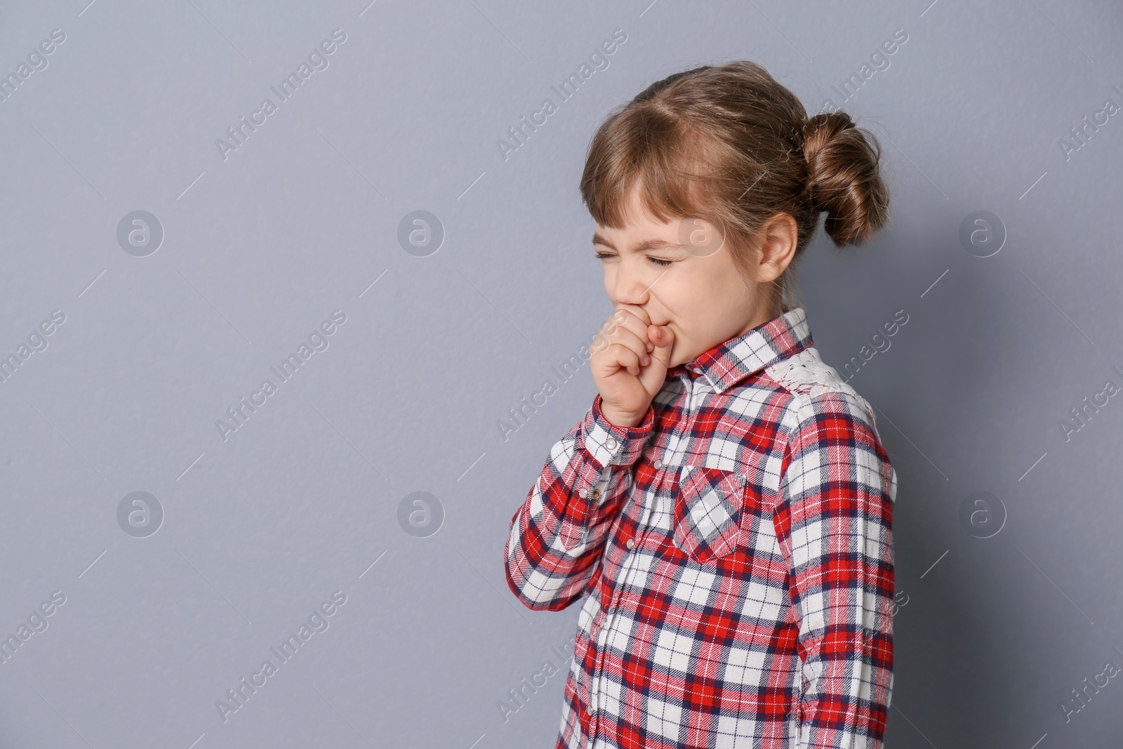 Photo of Little girl coughing on grey background