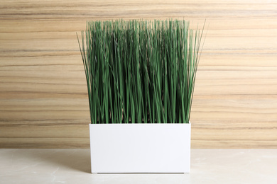 Photo of Artificial plant in flower pot on light grey marble table