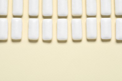 Photo of Tasty white chewing gums on beige background, flat lay. Space for text