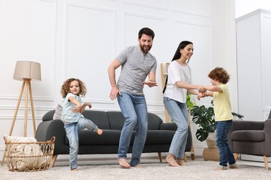 Happy family dancing and having fun in living room, low angle view