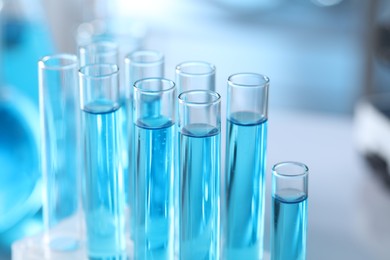 Photo of Test tubes with light blue liquid in laboratory, closeup