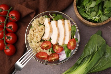 Photo of Delicious quinoa salad with chicken and cherry tomatoes served on grey textured table, flat lay