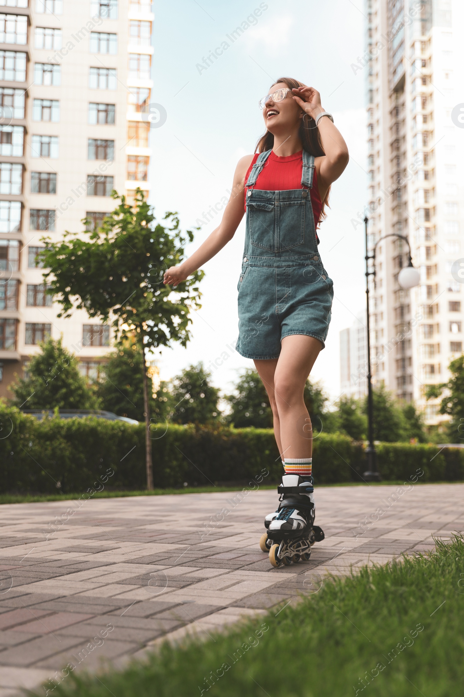 Photo of Beautiful young woman with roller skates having fun outdoors