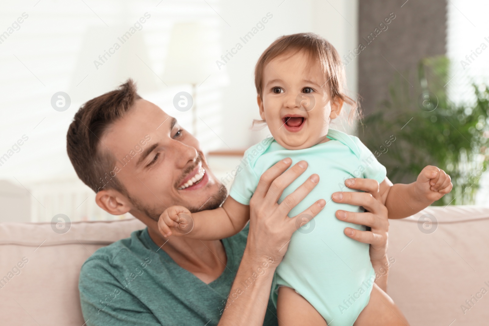 Photo of Father with adorable little baby at home. Happy family