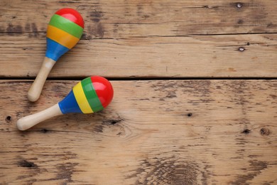 Photo of Colorful maracas on wooden table, top view with space for text