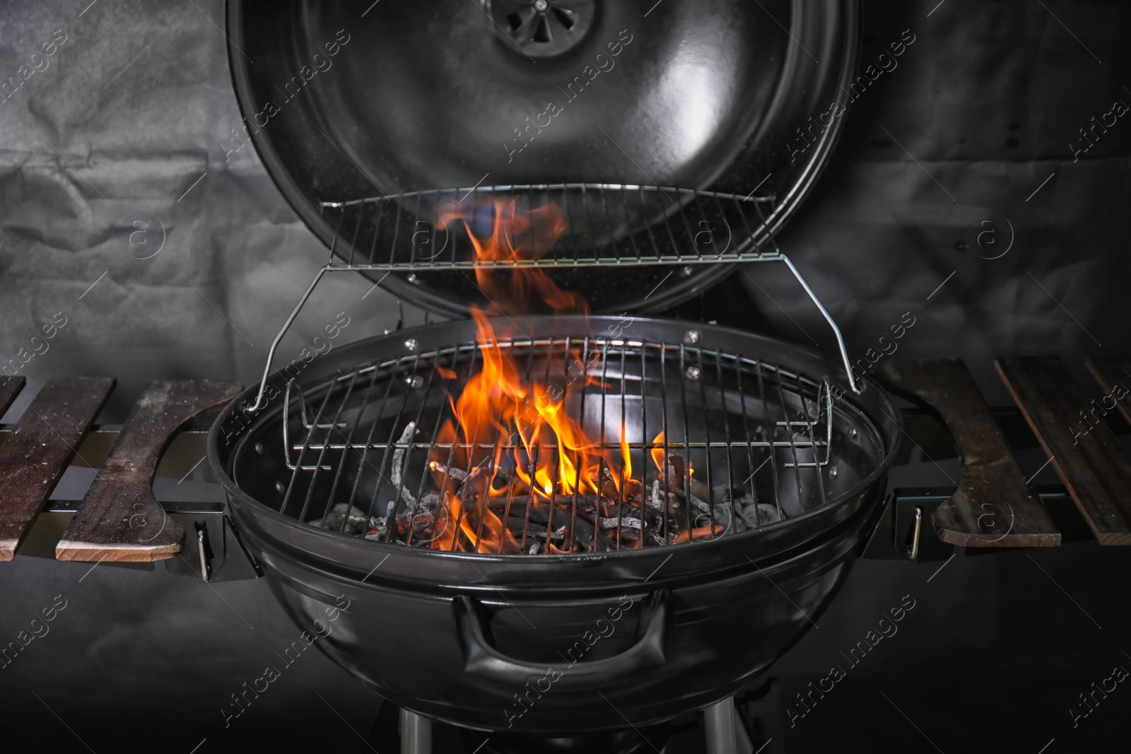 Photo of New modern barbecue grill with coals on black background