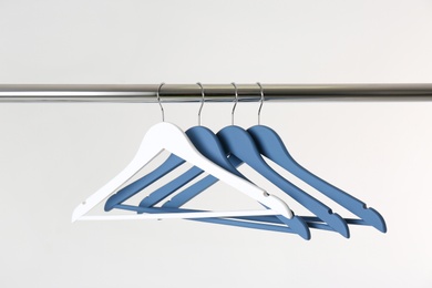 Metal rack with clothes hangers on white background