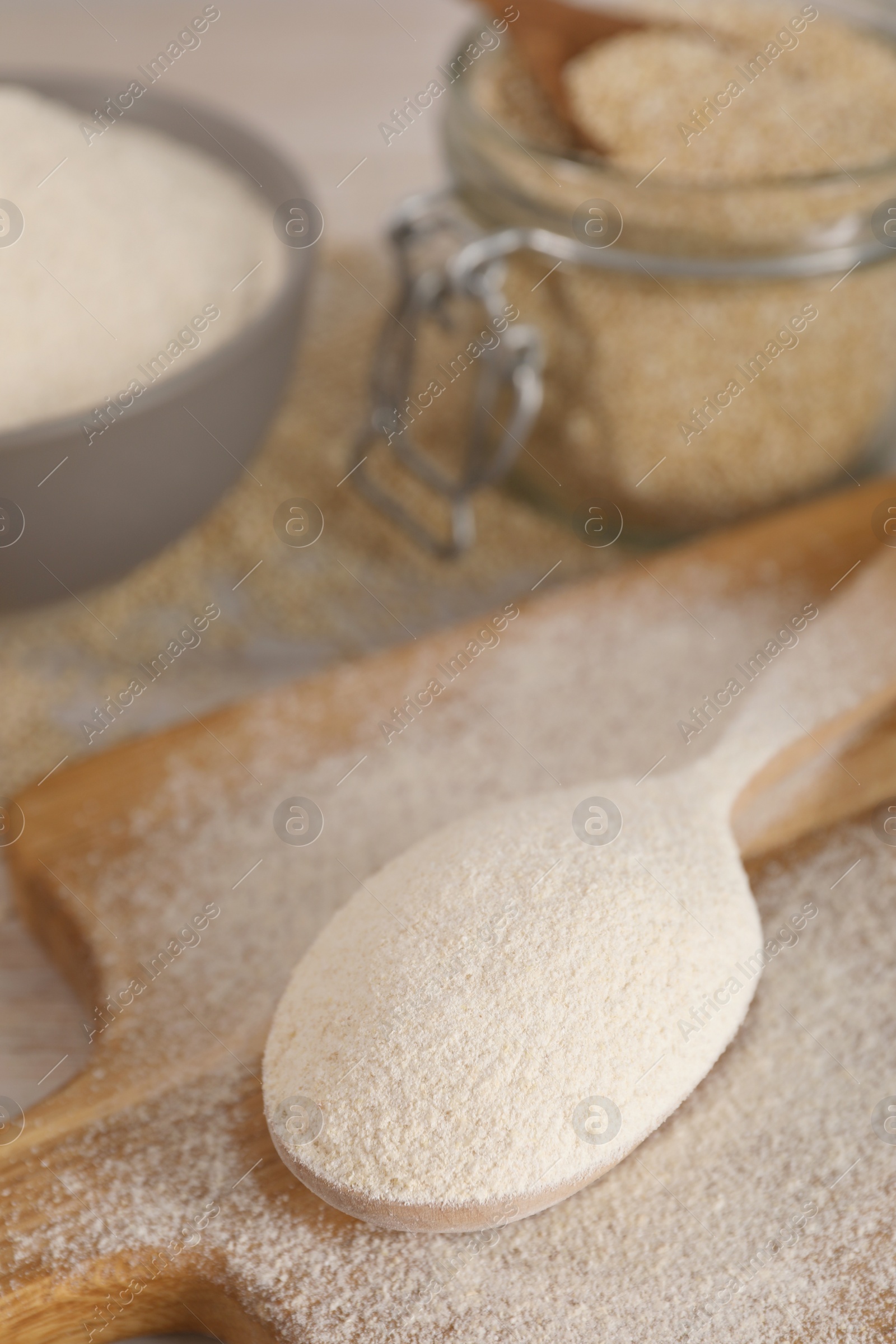 Photo of Spoon with quinoa flour on wooden table, closeup