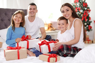 Happy parents and children exchanging gifts on Christmas morning at home